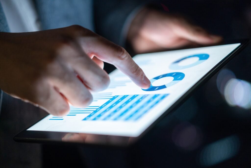 Man Holding Tablet Graphs Tables